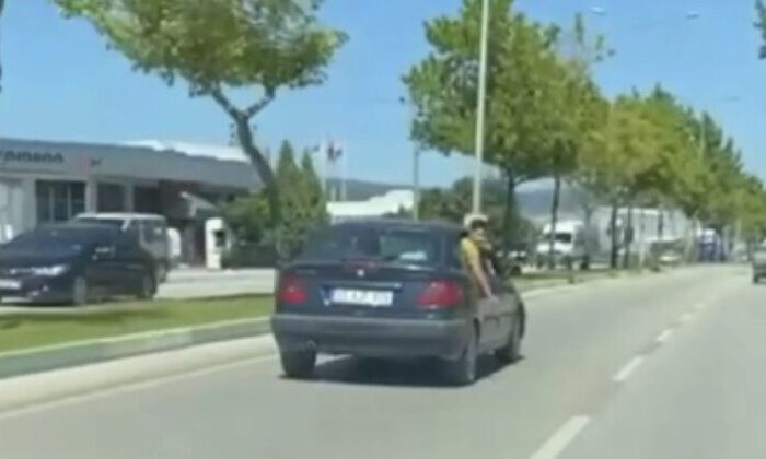 Canını hiçe sayan çocuk otomobilin camından sarktı